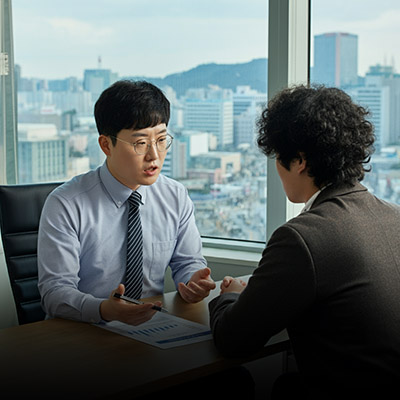 도심지가 보이는 창가에서 회의를 하고 있는 두 남자