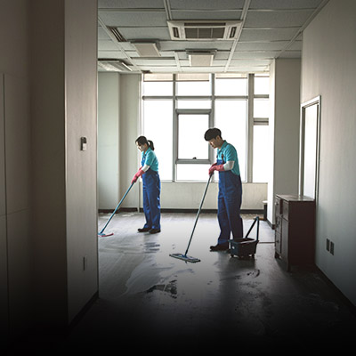 두 명의 사람이 비어있는 사무실을 청소하고 있다